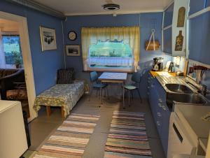 a kitchen with blue walls and a sink and a table at Sommarhus i Lofoten in Sand