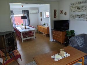 a living room with a television and a dining room at Sommarhus i Lofoten in Sand