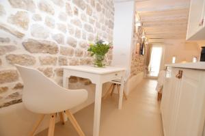 ロヴィニにあるApartment Al Pozzoの白いテーブルと白い椅子が備わるキッチン