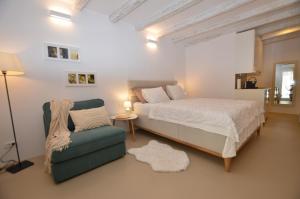 een slaapkamer met een bed en een stoel bij Apartment Al Pozzo in Rovinj