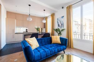 a living room with a blue couch and a kitchen at SMARTBNB - Appartement 2 pieces LUXE - Climatisé - ACROPOLIS in Nice