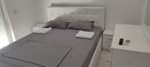 a bed in a small room with two pillows on it at Golem Apartment in Golem