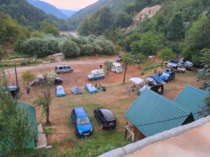 a group of cars parked in a field with mountains in the background at Kamp Vrbnica in Plužine