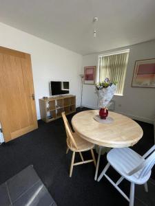 a room with a table and chairs and a television at 2 bedroom apartment in Kidderminster (The place to be) in Kidderminster