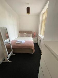 una piccola camera con letto e specchio di 2 bedroom apartment in Kidderminster (The place to be) a Kidderminster