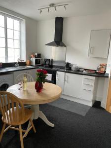 a kitchen with a table with a vase of flowers on it at 2 bedroom apartment in Kidderminster (The place to be) in Kidderminster