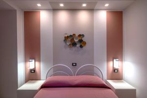 a bedroom with a pink bed with two lights at Residence Ranieri in Castiglione del Lago