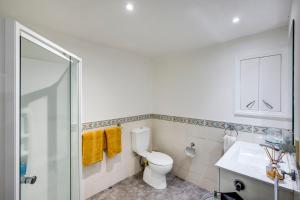 a bathroom with a toilet and a glass shower at Maison Blue - Chic Garden Apartment in Napier +16 photos