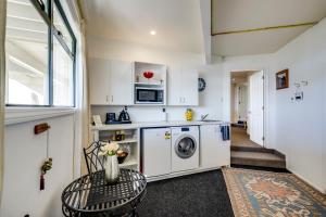 a laundry room with a washer and dryer at Maison Blue - Chic Garden Apartment in Napier