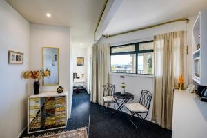 a living room with a window and a table and chairs at Maison Blue - Chic Garden Apartment in Napier