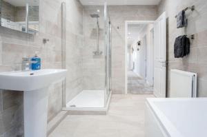 Un baño blanco con ducha y lavabo. en Springfield Lodge - 3 Bedroom Home - Princes Gate, en Pembrokeshire 48 fotos más