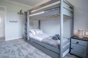 a bedroom with a bunk bed with white walls at Springfield Lodge - 3 Bedroom Home - Princes Gate in Pembrokeshire