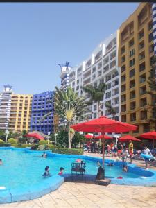 a large swimming pool with people in a resort at شاليه بورتو مارينا على البحر in El Alamein