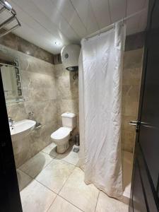 a bathroom with a toilet and a shower curtain at شاليه بورتو مارينا على البحر in El Alamein