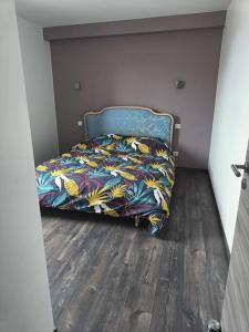 ein Bett mit farbenfroher Bettdecke in einem Schlafzimmer in der Unterkunft Appartement 