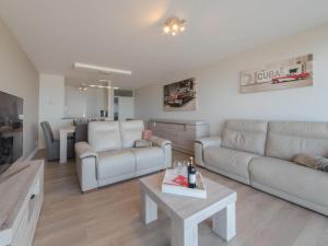 ein Wohnzimmer mit einem Sofa und einem Tisch in der Unterkunft Modern appartement met uitzonderlijk zeezicht! in Blankenberge