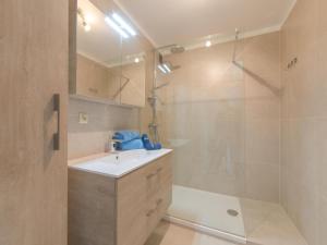 ein Bad mit einem Waschbecken und einer Dusche in der Unterkunft Modern appartement met uitzonderlijk zeezicht! in Blankenberge