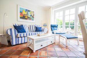 曼克玛肖Haus Moin的客厅里有一张沙发和两把椅子