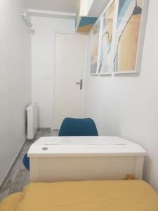 Zimmer mit einem weißen Schreibtisch und einem blauen Stuhl in der Unterkunft L'art et Deco RerC-n104-A6-A10 in Brétigny-sur-Orge