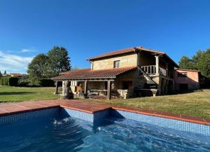 a large swimming pool in front of a house at Casa de campo con piscina, entera o por habitaciones in Amoeiro