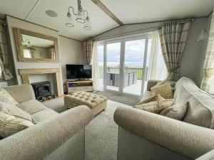Sala de estar con 2 sofás y TV en Luxury Lodge With Stunning Full Sea Views In Suffolk Ref 20234bs, en Hopton on Sea