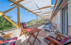 un patio con sedie, un tavolo e una tenda da sole di Awesome Home In Grebastica With Wifi a Grebaštica