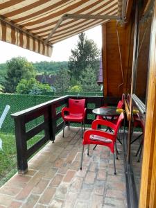 een patio met rode stoelen en een tafel op een terras bij Brvnara Beli Kamen 1 in Bešenovački Prnjavor