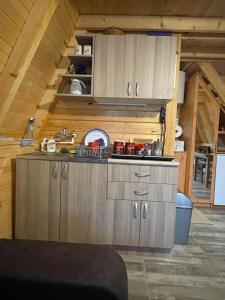 a kitchen with wooden cabinets in an attic at Brvnara Beli Kamen 1 in Bešenovački Prnjavor