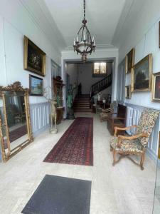 sala de estar con lámpara de araña y habitación con escalera en 5 Appar’T « Bien Méritée ». Maison Bardou en Amboise