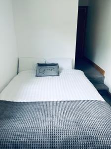 a white bed with a pillow on top of it at Wild Atlantic Way Rentals in Kenmare