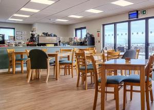 a restaurant with wooden tables and chairs and a counter at Haystax Holiday Lodges in Knitsley