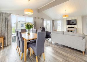 ein Wohnzimmer mit einem Tisch, Stühlen und einem Sofa in der Unterkunft Haystax Holiday Lodges in Knitsley