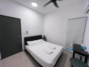 ein kleines Schlafzimmer mit einem weißen Bett und einem Schreibtisch in der Unterkunft METROPOL SERVICED APARTMENT at Bukit Mertajam, Pulau Pinang in Bukit Mertajam