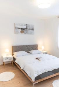a bedroom with a large bed with white sheets at Apartman Krželj B2 in Livno