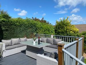 a patio with a table and chairs on a deck at Bungalow33 Benllech in Benllech