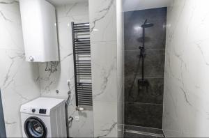 a bathroom with a shower and a washing machine at Apartman Krželj B2 in Livno +13 photos