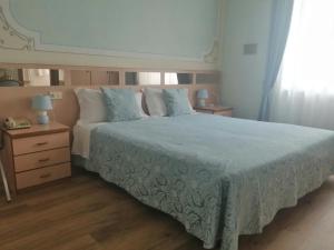 Albergo Stella Alpina في مولفينو: غرفة نوم بسرير كبير ومرآة