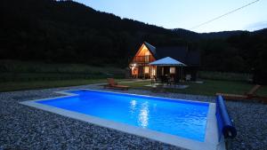 une grande piscine bleue en face d'une cabine dans l'établissement Vikendica sa bazenom MAGNUM, à Višegrad