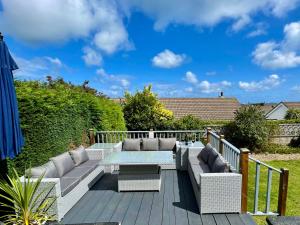 a patio with couches and a table on a deck at Bungalow33 Benllech in Benllech