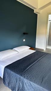 Bett in einem Schlafzimmer mit blauer Wand in der Unterkunft B&B SOUL Messina in Messina
