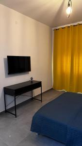 Zimmer mit einem Bett, einem TV und einem Tisch in der Unterkunft B&B SOUL Messina in Messina