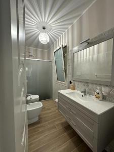 een badkamer met een wastafel, een toilet en een spiegel bij Villa Valentina in Cefalù