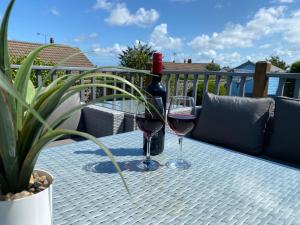 a bottle of wine and two glasses on a table at Bungalow33 Benllech in Benllech