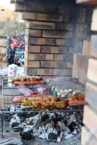a grill with meat and other food on it at Gîtes climatisés classés 4 étoiles Au Petit Bonheur de Lorigné in Lorigné