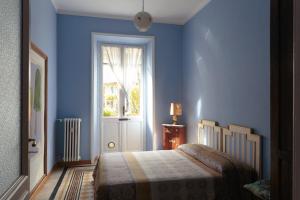 a blue bedroom with a bed and a window at Vanchiglia Apartment - Torino in Turin