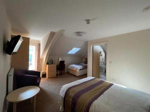 a hotel room with a bed and a desk and a table at Wingfield Hotel 