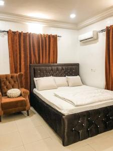 Posto letto in camera con sedia e letto Sidx Sidx Sidx. di Cozy 1 bedroom apartment in Abuja ad Abuja