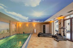 a fitness room with a swimming pool and a gym at Amber dream Karkle in Karklė