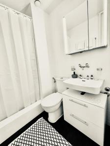 a white bathroom with a toilet and a sink at Cozy Studio Apartment Unit 11 in Center of Zurich in Zurich