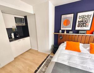 蘇黎世的住宿－Cozy Studio Apartment Unit 11 in Center of Zurich，一间卧室配有带橙色枕头的床,厨房